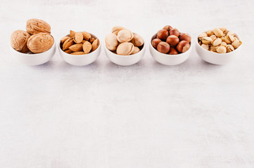 Background with various nuts in the small plates