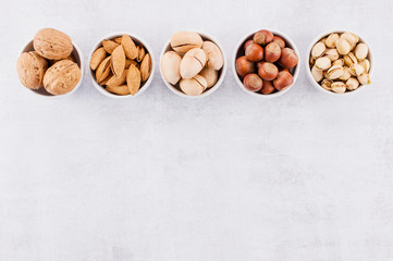 Background with various nuts in the small plates
