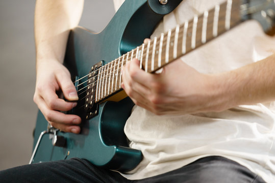 Close up of man playing on electric guitar