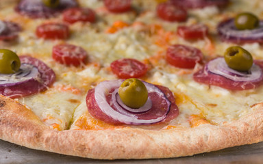 Italian pizza with cheese and olives on a baking sheet. Close-Up
