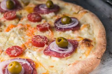 Italian pizza with cheese and olives on a baking sheet. Close-Up