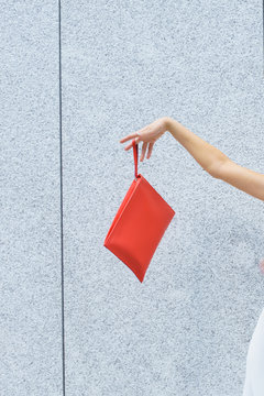 Unrecognizable woman showing red bag