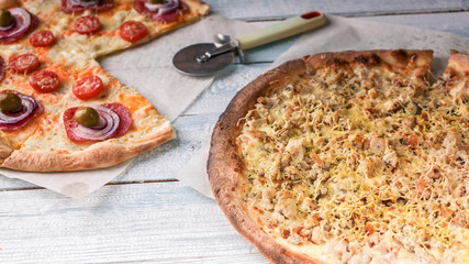 Italian pizza with salami and meat. Wooden rustic background