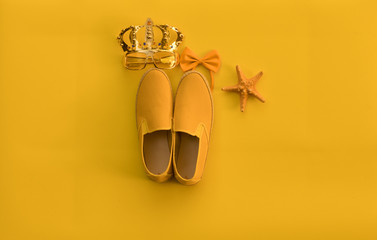 summer yellow boots on isolated yellow background, abstract concept