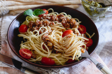 Spaggettes with bolognese sauce in a ceramic plate are on the dining table