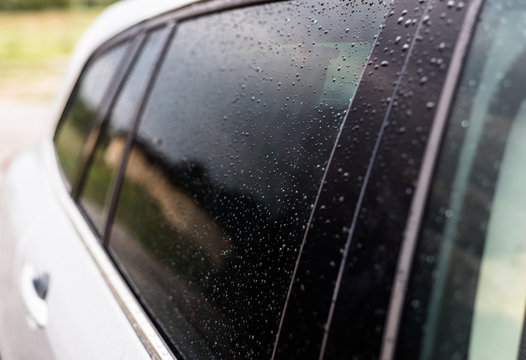 Raindrops On A Silver Car On The Side Rear Black Window Of The Car