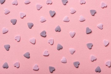 beautiful sweet pink sprinkles of heart shapes over pink background, concept of St. Valentines Day