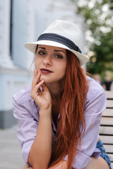 Portrait of beautiful redhair woman in a hat, summer outdoors