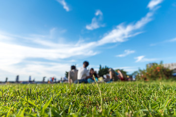 Friends and family having fun on a picnic on the lawn with bright blue sky. selectes focus.