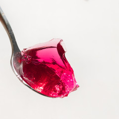 Red sweet jelly on a spoon