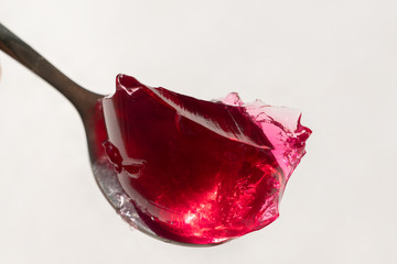 Dark red sweet jelly on a spoon