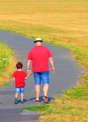 Overweight father with son walking on footpath. Hiking is outdoor sport for all. Summer vacations on countryside.