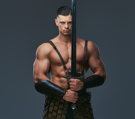 Brutal ancient Greece warrior with a muscular body in battle uniforms