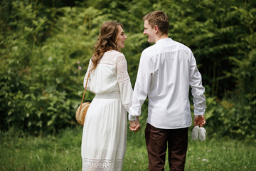 Fototapeta premium Happy pregnant family having fun time in summer nature. 