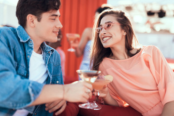 Outgoing girl and smiling man speaking while tasting delicious beverage. Happy couple during rest concept