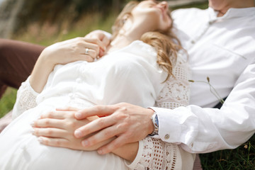 Obraz premium Happy pregnant family having fun time in summer nature. 