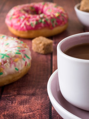 Donuts and coffee on wooden table. Top view with copy space