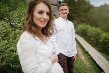 Fototapeta premium Happy pregnant family having fun time in summer nature. 