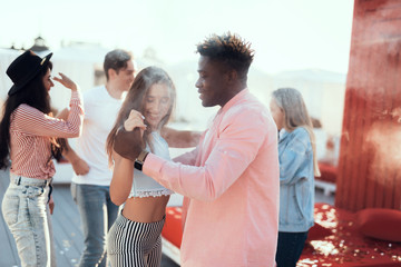 Happy girl dancing with cheerful male they talking together. Beaming friends gesticulating hands...