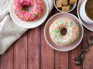 Donuts and coffee on wooden table. Top view with copy space