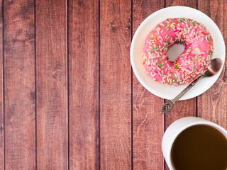 Donuts and coffee on wooden table. Top view with copy space