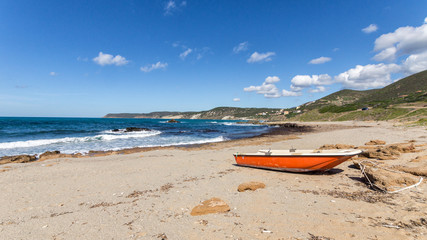 Orangefarbenes Boot am einsamen Strand