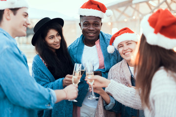 Smiling males and beaming girls tasting alcohol liquid during conversation. They having fun during party