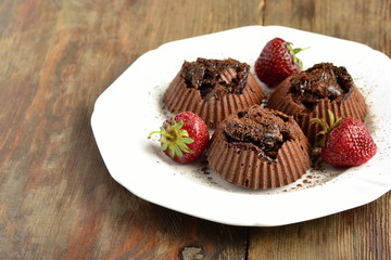 Delicious chocolate souffle with prunes and strawberries sprinkled with cocoa,  copy space