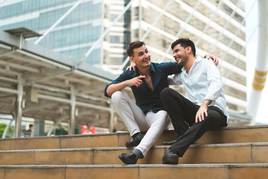 Two Friend Sitting Down On Stairs Shaking Hands. Businessmen Very Happy After Success Project. Concept Of Business Marketing, Negotiation, Compliment And Management.