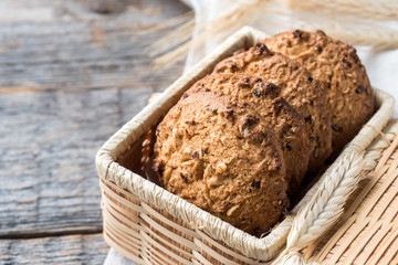 Oatmeal cereal cookies in wicker straw box wooden table