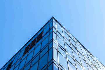 Glass facade of the buildings with a blue sky.