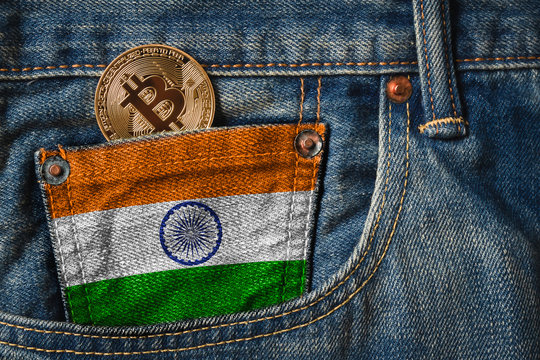 Golden BITCOIN (BTC) cryptocurrency in the pocket of jeans with the flag of Republic of India on Jeans Denim Texture.
