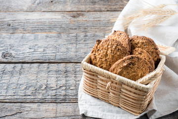 Oatmeal cereal cookies in wicker straw box wooden table