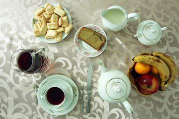 breakfast table with bread, fruits, tea and biscuits