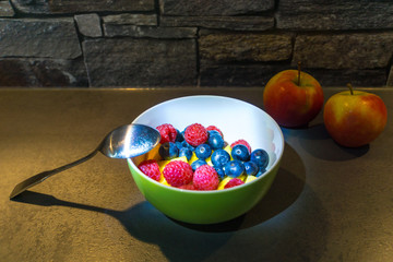 Two apples and colorful healthy fruit mix in dish