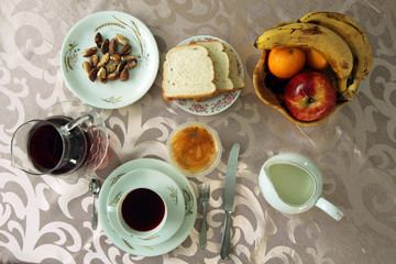 breakfast table with bread, fruits, tea and brazilian nuts