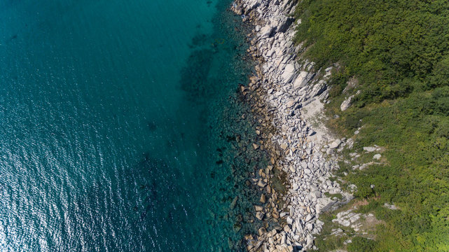 Aerial drone top view of rocky coast line on sunny summer day © Евгений Бахчев