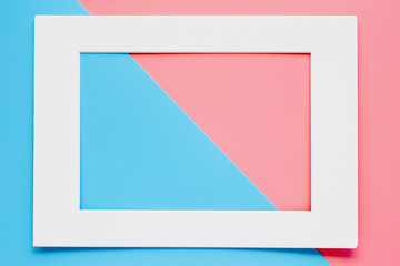 White paper frame on pink-blue pastel color background. Flat lay and top view image.