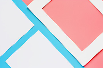 White paper frame on pink-blue pastel color background. Flat lay and top view image.