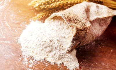 Wheat ears and flour on  background