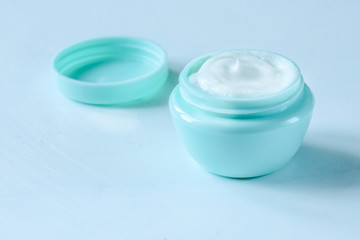 Organic natural cream for face and body skin in a green jar close-up.