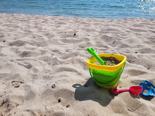 Fototapeta na wymiar children's toys on the beach with white sand on a sunny day