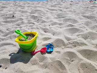 children's toys on the beach with white sand on a sunny day