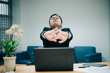 Asian officer man stretching body at the desk of office from back angle,Thailand people,Businessman...