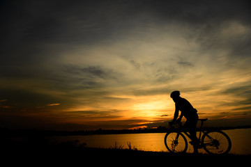 Obraz premium Silhouette of biker ride bicycle on sunset
