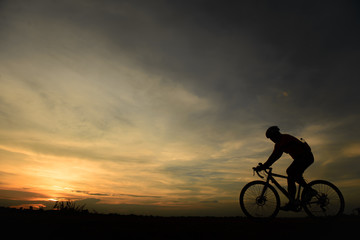 Fototapeta na wymiar Silhouette of biker ride bicycle on sunset