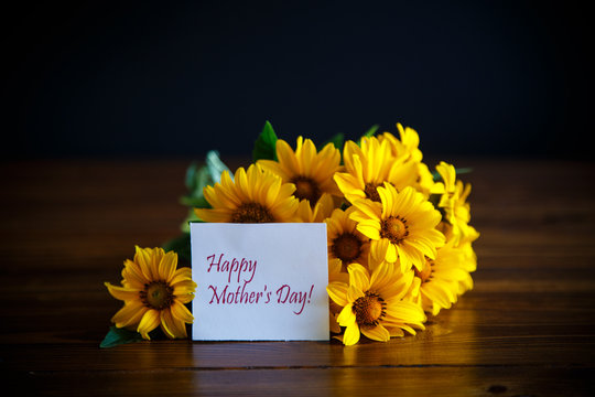 Fototapeta bouquet of yellow big daisies on a black