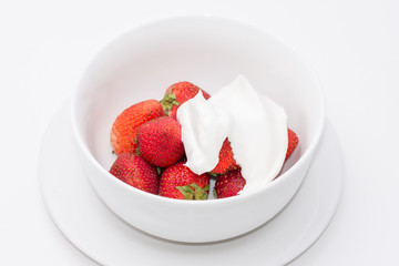 Fresh strawberries and cream in white bowl with room for copy text