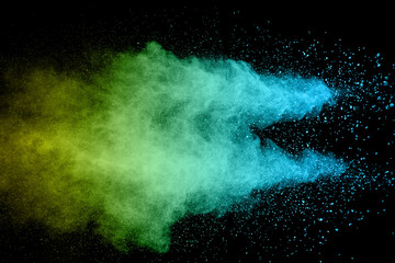 Explosion of color powder on black background. Splash of color powder dust on dark background.