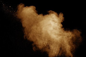 Abstract orange dust explosion on  black background.